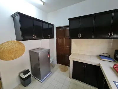 a kitchen with black cabinets and a stainless steel refrigerator at Azam Homestay in Seri Manjung