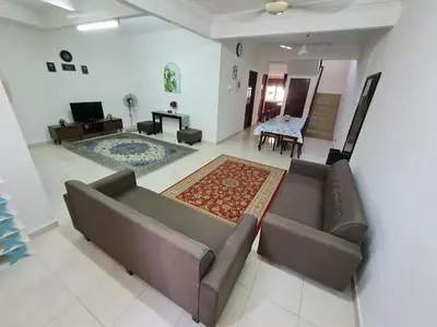 a living room with a couch and a dining room at Azam Homestay in Seri Manjung