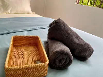 a stuffed animal sitting on a bed next to a basket at Kek Lok Si Inn in Ayer Itam