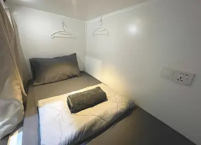a small room with a bed and a pillow at Kek Lok Si Inn in Ayer Itam