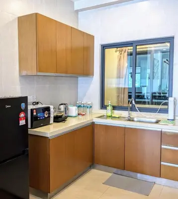 a kitchen with wooden cabinets and a sink and a window at The Retreat Mountain & Sunrise view Hilltop Hotel Apartment in Cameron Highlands in Cameron Highlands