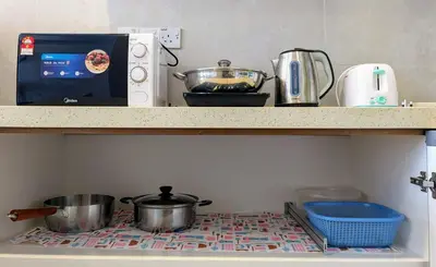 a kitchen with pots and pans on a shelf at The Retreat Mountain & Sunrise view Hilltop Hotel Apartment in Cameron Highlands in Cameron Highlands