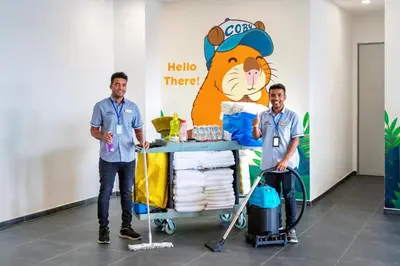 two men standing next to a table with a tiger on the wall at Marc CoLiving by Cobytat in Bukit Mertajam