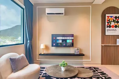 a living room with a tv and a couch and a table at Marc CoLiving by Cobytat in Bukit Mertajam