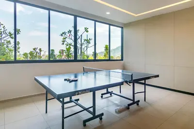 a ping pong table in a room with windows at Marc CoLiving by Cobytat in Bukit Mertajam