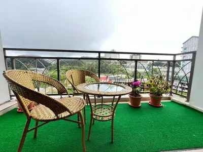 a patio with three chairs and a table on a balcony at Nova Sunrise & Mountain view Hilltop in Cameron Highlands in Brinchang