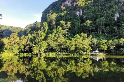 a reflection of a mountain in a body of water at Magnificent Mountain & Lake Views' Suite Cycas in Kampong Batu Lapan