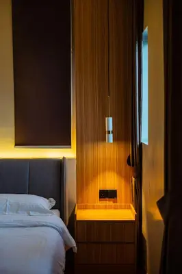 a bedroom with a bed and a night stand with a window at Ipoh Modern Luxury House 4B3B 14 pax in Kampong Baharu Ampang