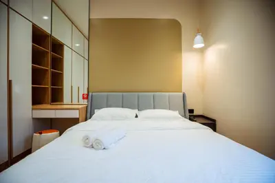 a bedroom with a large white bed with towels on it at Ipoh Modern Luxury House 4B3B 14 pax in Kampong Baharu Ampang