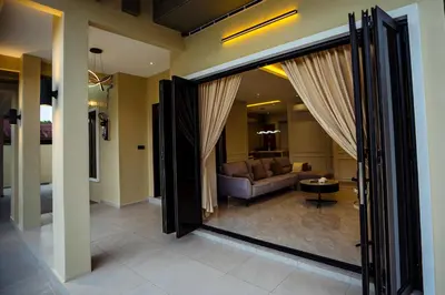 a living room with a couch and a large sliding glass door at Ipoh Modern Luxury House 4B3B 14 pax in Kampong Baharu Ampang