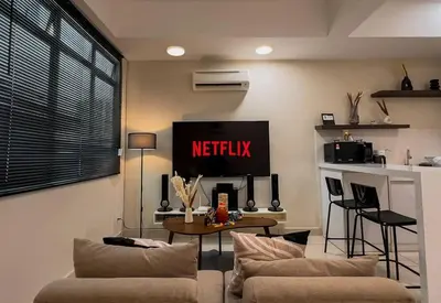a living room with two couches and a tv at Modern Minimalist Home Retreat near Lake Garden in Taiping