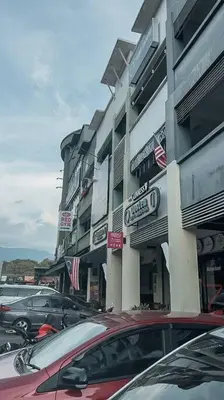 a parking lot with cars parked in front of a building at Modern Minimalist Home Retreat near Lake Garden in Taiping