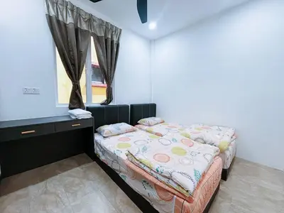 a bedroom with two beds and a window at Trace Cozy Place in Teluk Intan