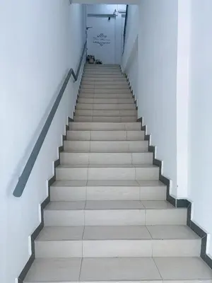 a staircase in a building with a dog sitting on the floor at Trace Cozy Place in Teluk Intan