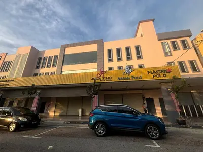 a blue car parked in a parking lot in front of a building at Trace Cozy Place in Teluk Intan
