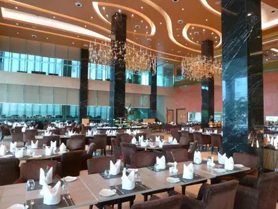 a dining room with tables and chairs and chandeliers at The Light Hotel Penang in Perai