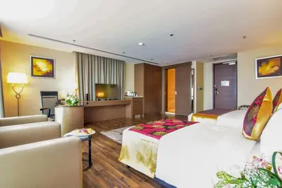 a hotel room with a large bed and a living room at The Light Hotel Penang in Perai
