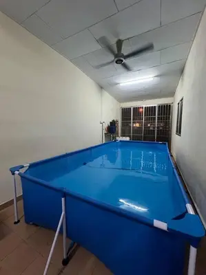 a large blue pool in a room with a ceiling at Family choice Ling53 in Sitiawan