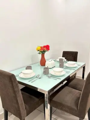 a table with chairs and a vase of flowers on it at Mansion One Modern 5pax walking distance Gleneagles Hospital Gurney Plaza in George Town