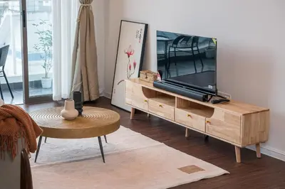 a living room with a flat screen tv on a wooden stand at Serene Zen Family Retreat 2 to 7pax&Sunrise View in Brinchang