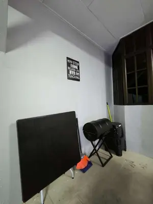 a room with a black chair and a sign on the wall at Homestay Last World Tambun in Kampong Batu Lapan