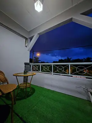 a room with a balcony with a table and chairs at Homestay Last World Tambun in Kampong Batu Lapan