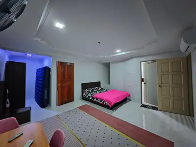 a bedroom with a pink bed and a door at Homestay Last World Tambun in Kampong Batu Lapan