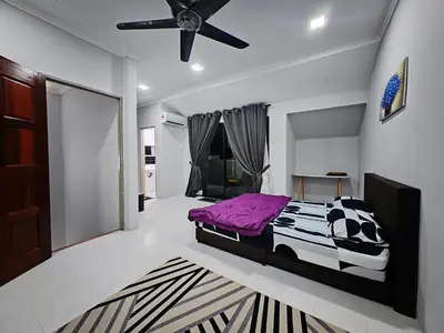 a bedroom with a purple bed and a ceiling fan at Homestay Last World Tambun in Kampong Batu Lapan