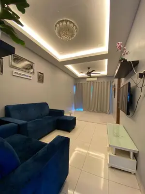a living room with a blue couch and a tv at Teratak Raffa Homestay in Kampong Tebing Rabak