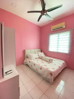a pink bedroom with a bed and a ceiling fan at Teratak Raffa Homestay in Kampong Tebing Rabak