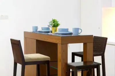 a wooden table with two chairs and a table with dishes at 118 Island Plaza Penang in Tanjong Tokong