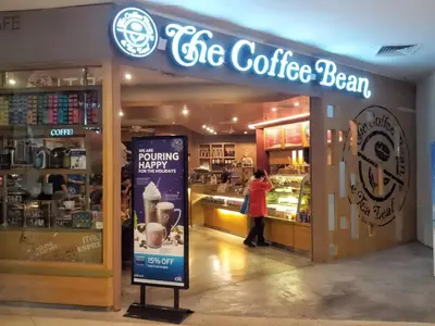 a woman standing in front of a coffee shop at 118 Island Plaza Penang in Tanjong Tokong