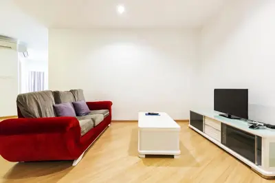 a living room with a red couch and a tv at 118 Island Plaza Penang in Tanjong Tokong