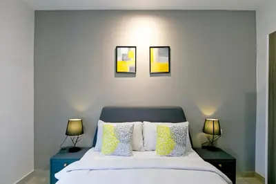 a bedroom with a bed with three pictures on the wall at Manhattan Suites Ipoh in Kampong Makam