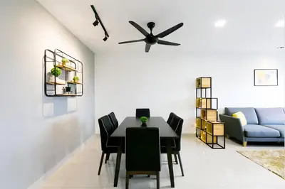a dining room with a table and chairs and a couch at Manhattan Suites Ipoh in Kampong Makam
