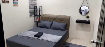 a bed in a room with a mirror at Doleena's Homestay in Sitiawan