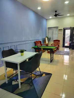 a living room with a table and ping pong tables at Doleena's Homestay in Sitiawan