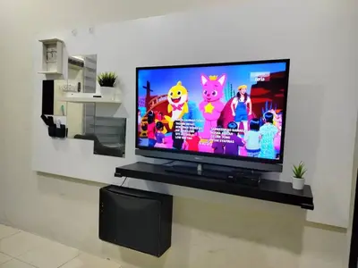 a flat screen tv sitting on a stand in a living room at Doleena's Homestay in Sitiawan