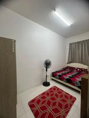 a bedroom with a bed and a floor fan at Melati Homestay Cameron Highland in Tanah Rata