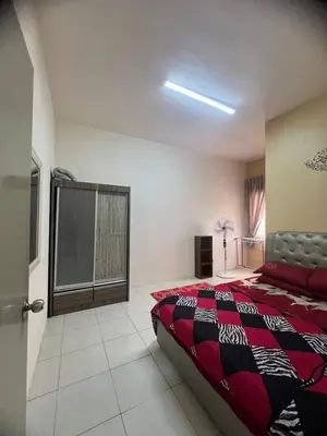 a bedroom with a bed with a red and black blanket at Melati Homestay Cameron Highland in Tanah Rata