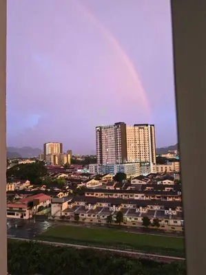 a rainbow in the sky over a city with buildings at Helena Homes - Premium Cozy Ipoh Homestay in Kampong Simee