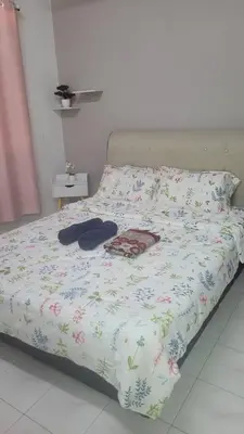 a bed with a bedspread with flowers on it at Ummi Homestay in Kampong Batu Tiga