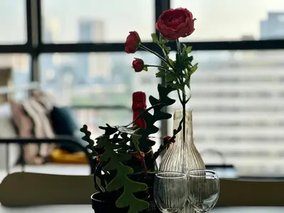 a vase with a rose and two glasses on a table at View of Whole Georgetown Sea&City View 3BR-12 a27 in Jelutong