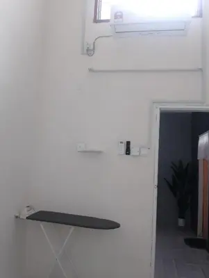 a room with a white wall and a window and a treadmill at D'Farah Homestay Teluk Intan 3Bilik in Teluk Intan