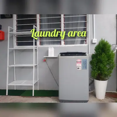 a small refrigerator next to a shelf and a plant at D'Farah Homestay Teluk Intan 3Bilik in Teluk Intan