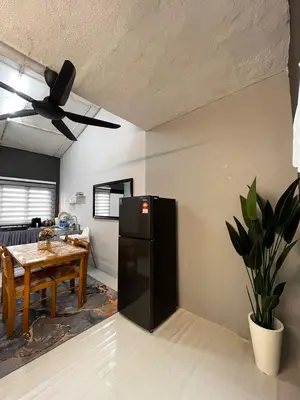 a kitchen with a black refrigerator and a table at D'Farah Homestay Teluk Intan 3Bilik in Teluk Intan