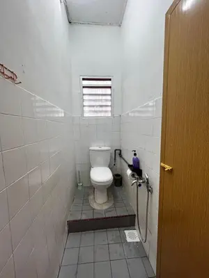 a bathroom with a toilet in a white tiled room at D'Farah Homestay Teluk Intan 3Bilik in Teluk Intan