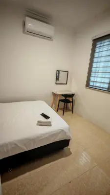 a bedroom with a bed and a table and a window at 23 Inn Queenbed Room with share bathroom in Simpang Ampat