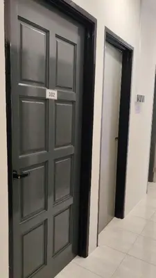a door with a sign on it in a hallway at 23 Inn Queenbed Room with share bathroom in Simpang Ampat