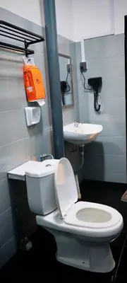 a bathroom with a white toilet and a sink at 23 Inn Queenbed Room with share bathroom in Simpang Ampat